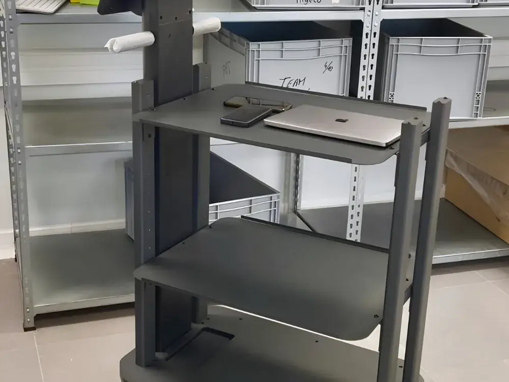 Robot de transport à plateaux dans une réserve, entre étagères métalliques et bacs de préparation