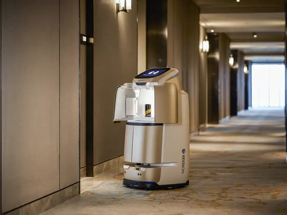 Robot de room service KEENON dans un couloir d'hôtel, compartiment ouvert avec une boisson