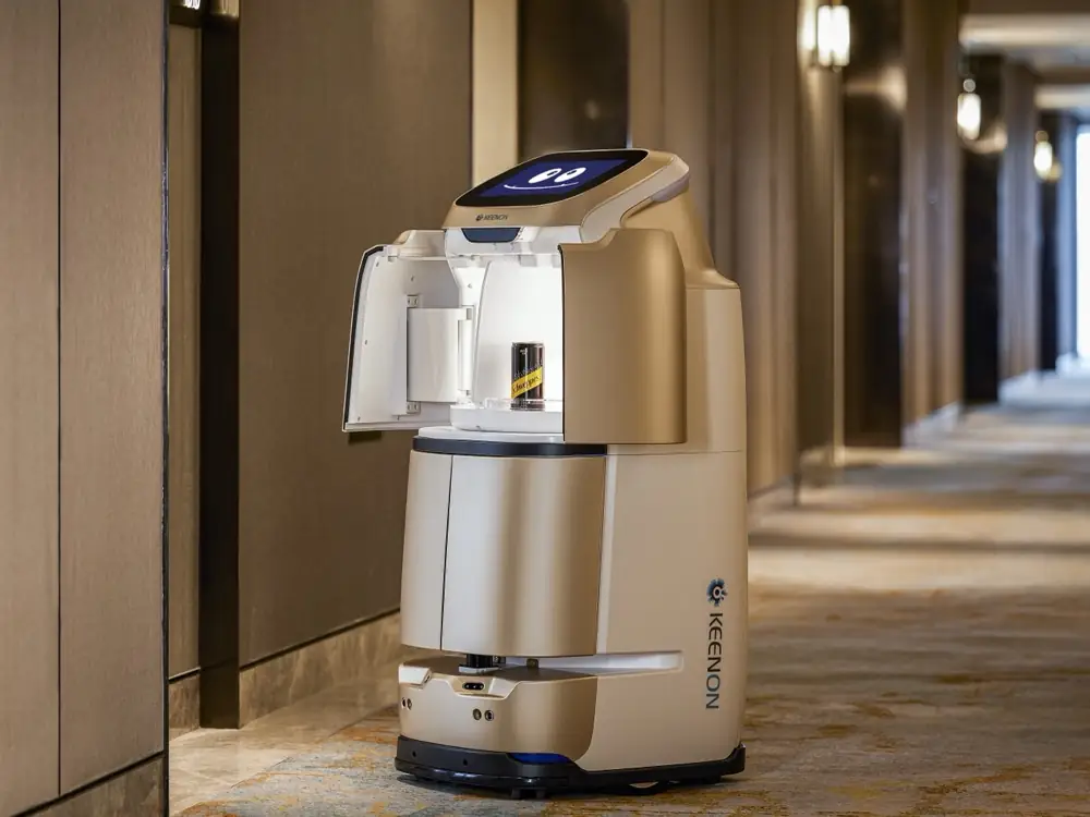 Robot de livraison hôtelier devant une porte de chambre
