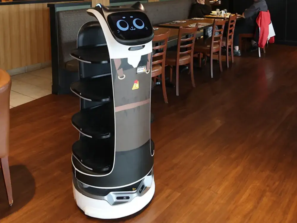 Robot serveur à étagères circulant en salle de restaurant